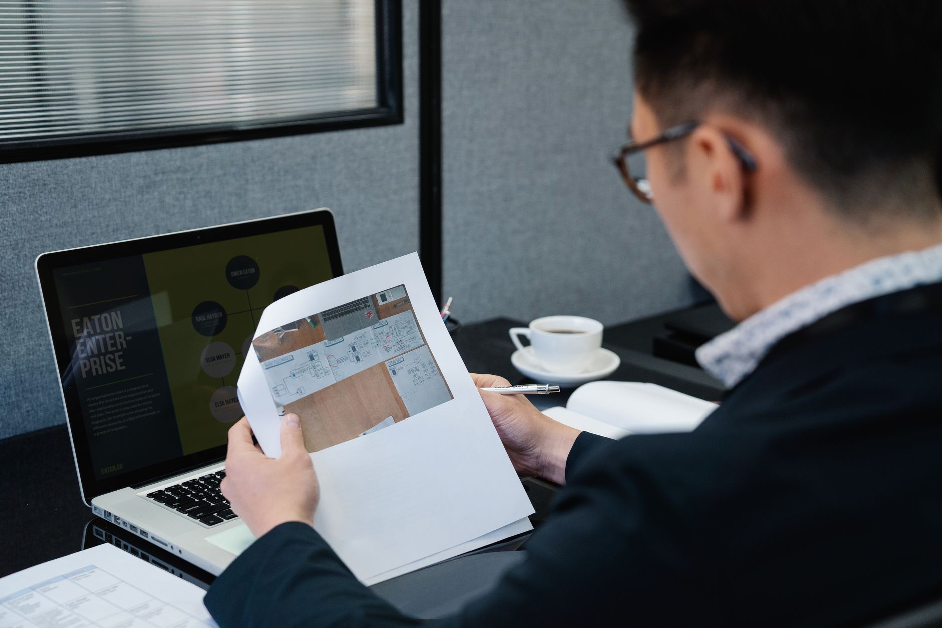 A man in an office setting analyzing documents with a laptop open nearby — illustrating: Virtual Front Desk Solutions for Central Florida SMBs: Which Provider Fits Your Workflow